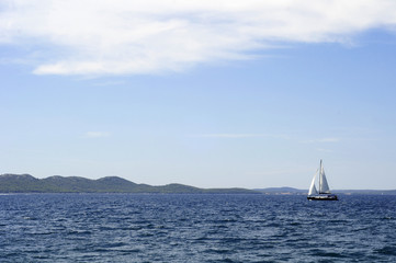 Obraz premium Adria - Segelboot am Meer mit Hügeln
