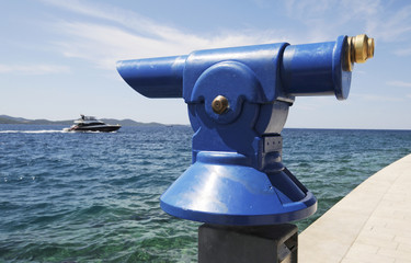 Fernrohr am blauen Meer mit Boot