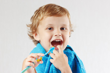 Little cute boy with toothbrush with pink toothpaste