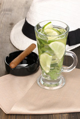 Mojito and a hat on a gray wooden background