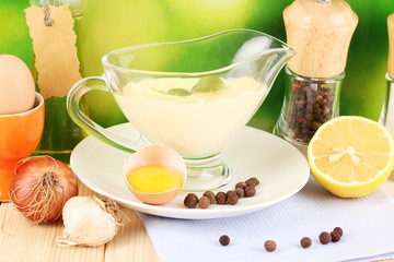 Mayonnaise in bowl close-up on wooden table on nature