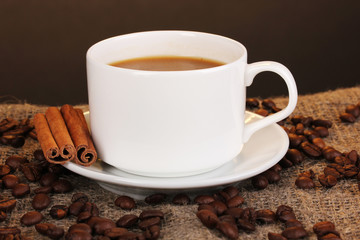 Cup of coffee on sacking on brown background