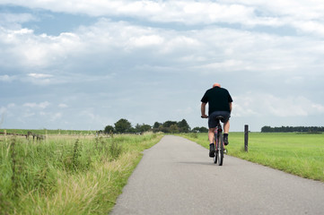 Man riding a bike through the fields