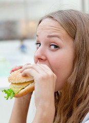 beauty girl in cafe eating hamburger