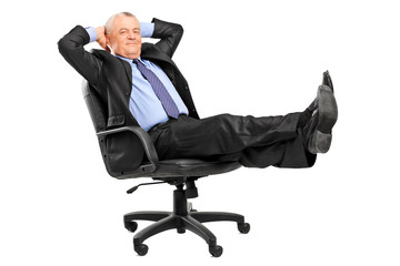 Mature businessman resting in armchair with legs up