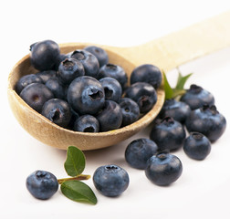 Fresh blueberries spilling from vintage wooden spoon