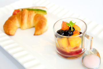 Breakfast with croissant and fresh fruit salad