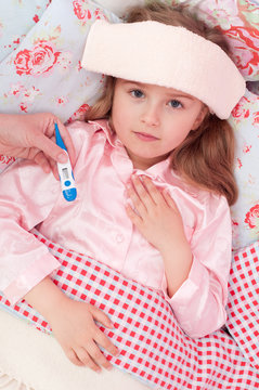 Cold and flu - child with fever in the bed