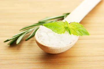 salt in spoon with fresh  rosemary and basil