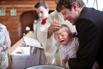 Adorable baby boy in christening dress being baptized - obrazy, fototapety, plakaty