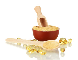 Gelatin in a bowl and wooden spoon on white background close-up
