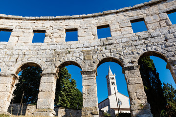 White Church Framed in the Arch of Ancient Roman Amphitheater in