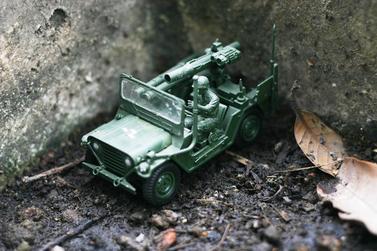 A toy soldier with jeep on his mission in the forest garden.