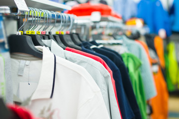 Obraz premium Variety of shirts and t-shirts on stands in supermarket