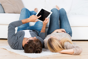 mann zeigt seiner freundin etwas am tablet