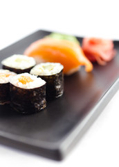 Black rectangle plate with sushi rolls, isolated