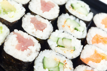 Sushi rolls on black plate close-up