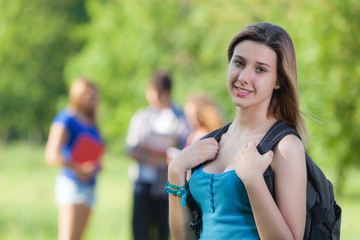 Fototapeta na wymiar Young Female Student at Park with Other Friends