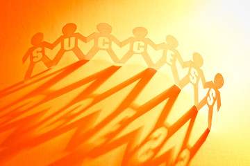 Success of paper doll people holding hands 