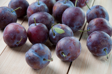 Horizontal shot of ripe plums on wooden boards