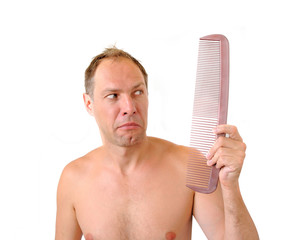 Surprised man hand holding comb near the head