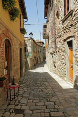 Panele Szklane Podświetlane  wąska kamienista ulica w toskańskim borgo Montefioralle
