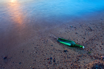Bottle with the message on sea coast
