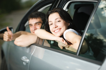 Beautiful happy young couple driving the car