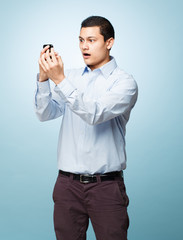 Happy young man holding mobile phone