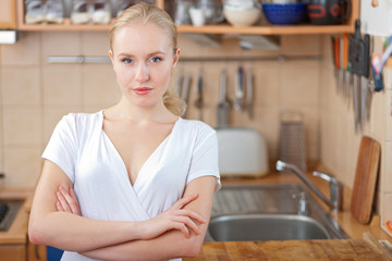 Beautiful relaxed woman standing at the kitchen counter 