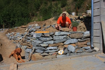 man builds a stone wall