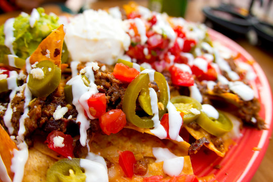 Mexican appetizer of nacho chips loaded with beef, cheese