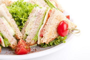frisches Clubsandwich mit Schinken, Käse, Speck und Salat isoli