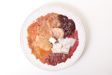 Raw pork steaks, minced meat and slides of ham on the plate
