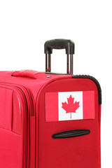 red suitcase with sticker with flag of Canada isolated on white