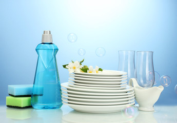 empty clean plates and glasses with dishwashing liquid, sponges