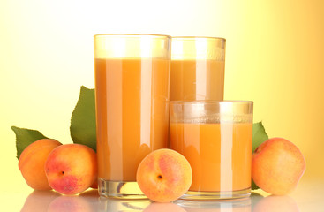 glasses of apricot juice on yellow background