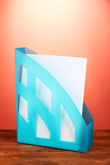 Blue tray for papers on red background close-up