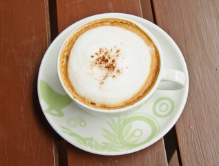 Top view of coffee cup on wooden background