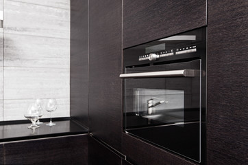 Part of black hardwood kitchen with build-in microwave oven