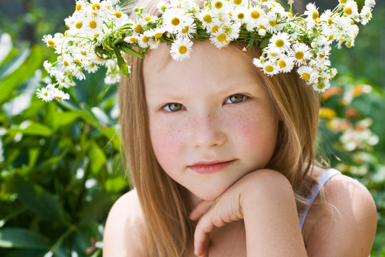 A pretty little girl in wreath of flowers