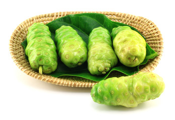 Noni fruits in basket on white background
