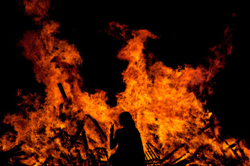 woman standing in front of a big fire