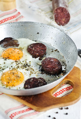 Fried eggs and blood pudding sausage