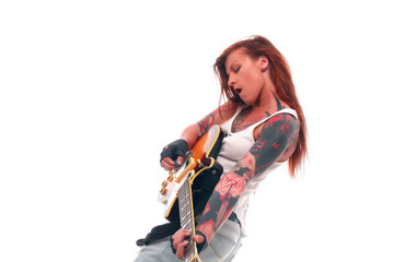 Attractive punk girl with tattoos playing electrical guitar