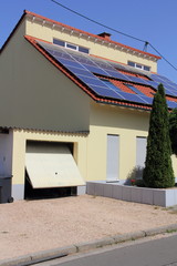 gelbes Einfamilienhaus mit Solarzellen