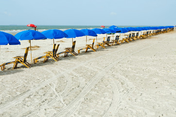 Beach lounge chairs with umbrellas. - obrazy, fototapety, plakaty