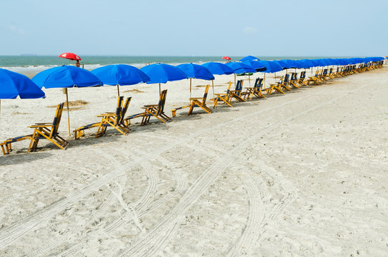 Beach lounge chairs with umbrellas.