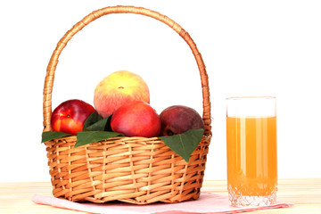 Ripe peaches in basket and juice