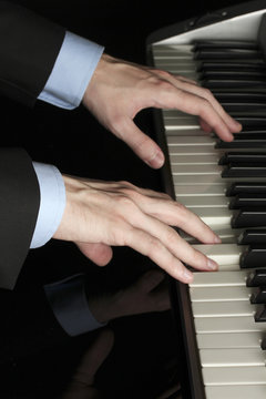 man hands playing piano